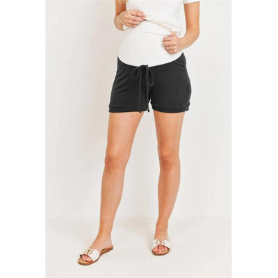 Solid black maternity track shorts with a drawstring waist, worn by a woman with a white top and sandals.