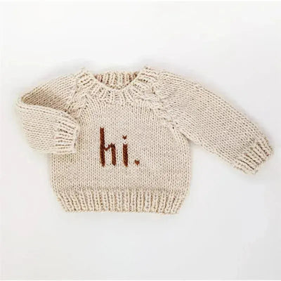 Cream-colored knit crew neck sweater for babies and toddlers with “hi.” embroidered in brown on the front.