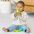Infantino Farmers Market Teether Gift Set shown with a baby sitting on the floor, chewing a green and yellow corn-shaped teether.