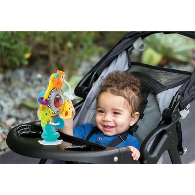 Baby smiles while holding the Infantino Jungle Ferris Wheels toy in a stroller, featuring colorful animals and spinning elements.