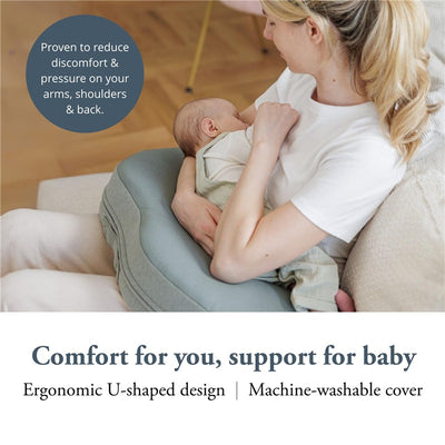 Ergonomic U-shaped nursing pillow in Balance Green, supporting a mother comfortably holding her baby.
