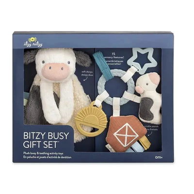 Plush Itzy Ritzy Bitzy Busy Gift Set featuring a cow lovey and varios sensory toys, designed for infants aged 0 months and older.