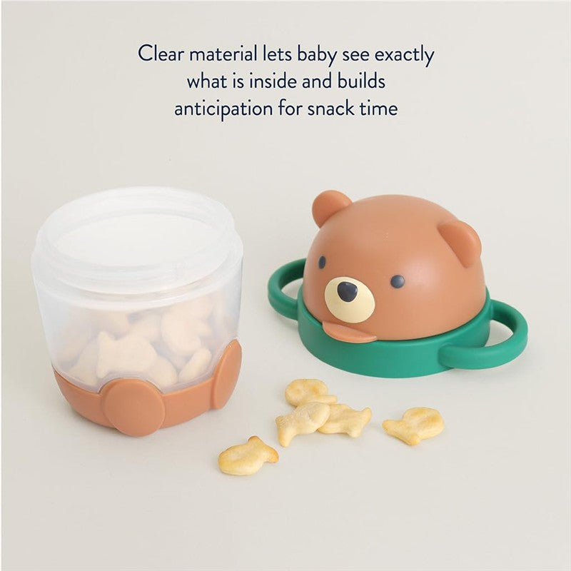 Itzy Ritzy Itzy Snack Pal in bear design, featuring a clear container for snacks, with fish-shaped treats visible inside.