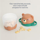 Itzy Ritzy Itzy Snack Pal in bear design, featuring a clear container for snacks, with fish-shaped treats visible inside.