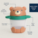 Mess-free snack cup designed like a bear, featuring an attached lid, clear material for visibility, and easy-grip handles.