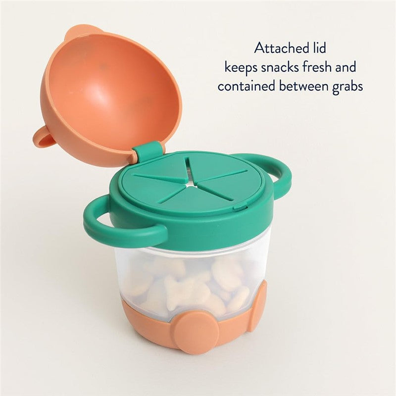 Itzy Ritzy Itzy Snack Pal in bear design, featuring a green lid and transparent container, holding snacks inside.