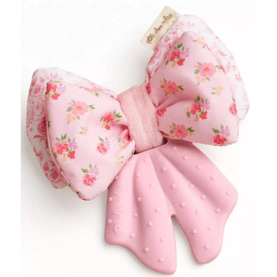 Silicone sensory teether shaped like a bow, featuring a floral design in pink with a textured rubber base.