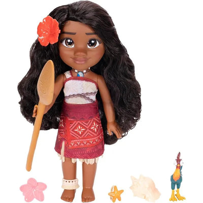 Singing Moana doll with long black hair, flower accessory, holding a wooden paddle, surrounded by colorful accessories.