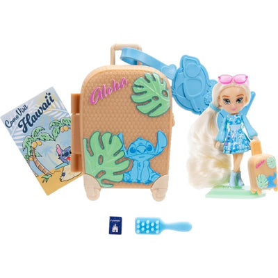Tween doll with long hair, wearing a blue dress, beside a suitcase decorated with Stitch, a Hawaiian postcard, and accessories.