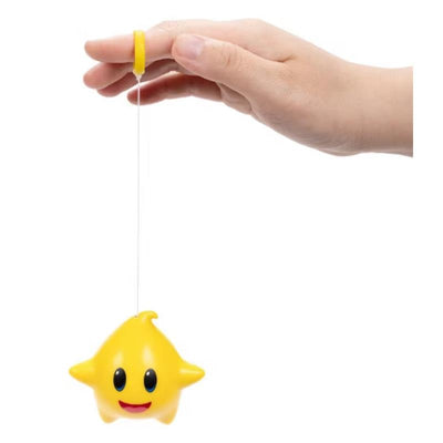 Yellow Luma star toy from the Super Mario Galaxy movie, held by a hand, featuring a retractable string for play.