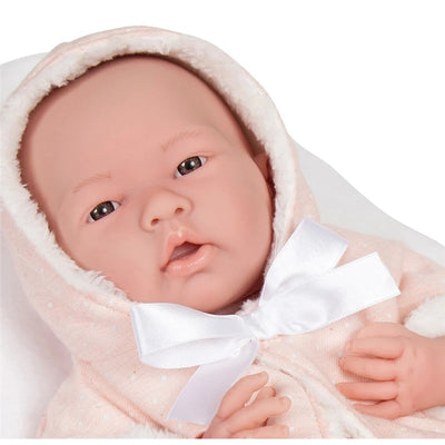 La Newborn All-Vinyl Baby Doll wearing a pink coat with a white bow and a soft hood, looking directly at the viewer.