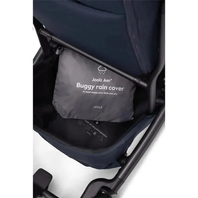 Grey storage pouch for the Joolz Aer+ buggy rain cover, labeled with product and care information, inside a stroller basket.