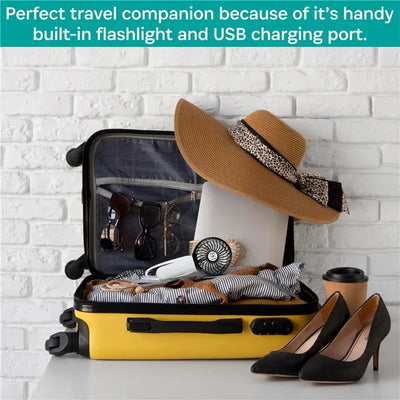 Yellow suitcase partially open, filled with sunglasses, a hat, a small fan, laptop, and shoes, set against a white brick wall.
