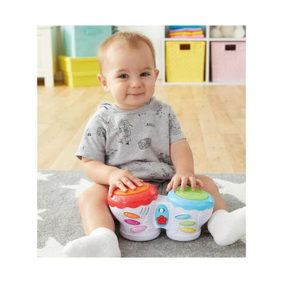 Toddler playing with Kidoozie Flash Beat Drums, colorful toy drums with buttons, sitting on a soft carpet.
