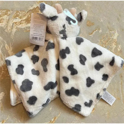 Soft white plush cow snuggler blanket with gray spots, featuring a cow head and hands at the top.