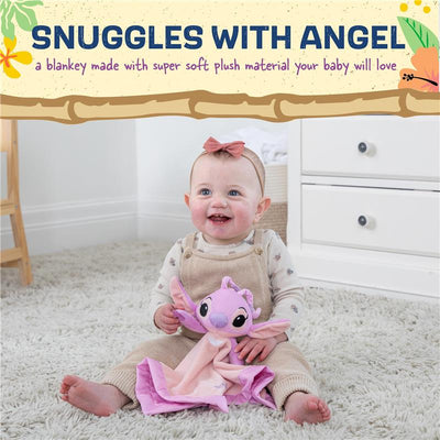 Toddler in beige overalls with a pink bow holds a plush Lilo and Stitch angel blanket, smiling on a soft rug.