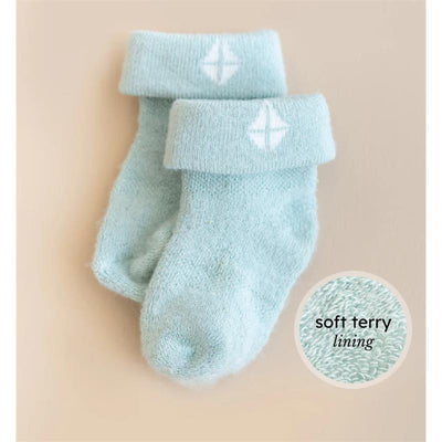 Soft blue baby socks with a cuff and white logo, highlighting the soft terry lining.