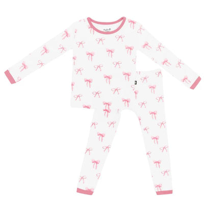 Long sleeve white pajamas for baby girls featuring a pink bow pattern and pink trim on the collar and cuffs.