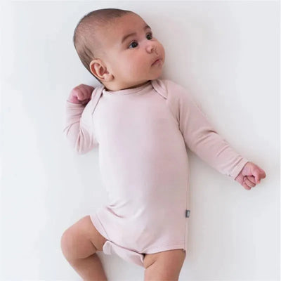 Long sleeve bodysuit in blush on a baby, featuring soft fabric and a simple design, lying on a light background.