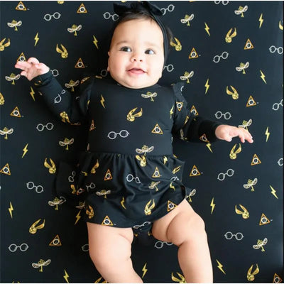 Long sleeve twirl bodysuit dress in black with Harry Potter-themed prints, featuring a baby smiling with a headband.