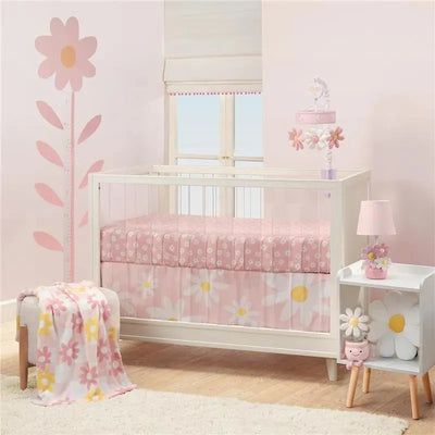 Changing pad cover featuring a pink daisy design, set in a nursery with a crib, decorative lamp, and plush toys.
