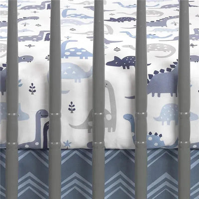 Fitted crib sheet featuring a dinosaur print in shades of blue and gray, placed in a crib with gray slats.