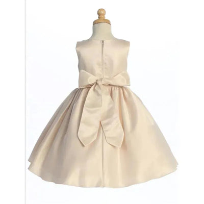 Satin baby girl dress in chardonnay color with a large bow at the waist and a zipper closure at the back.