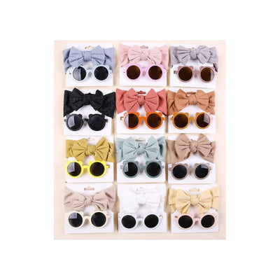 Baby sunglasses and matching headbands in various colors arranged in a grid on display cards.