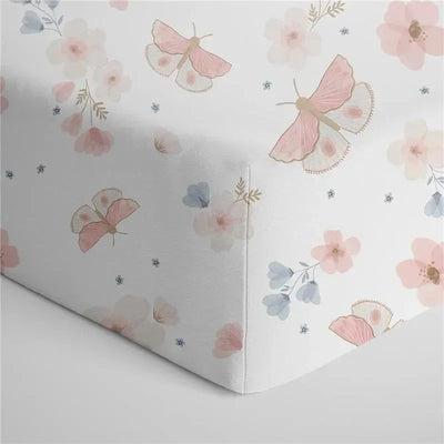 Cotton jersey crib fitted sheet featuring a floral and butterfly design in soft pink, blue, and white colors.