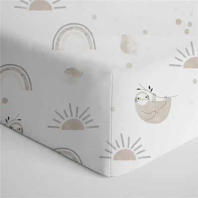 100% cotton crib fitted sheet featuring playful sloth and rainbow patterns in soft, neutral colors.