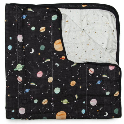 Muslin quilt featuring colorful planets and constellations on a black background, with a contrasting starry white underside.