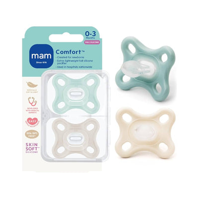 Two Mam Comfort pacifiers for newborns, one mint green and one beige, displayed in a clear packaging with care instructions.