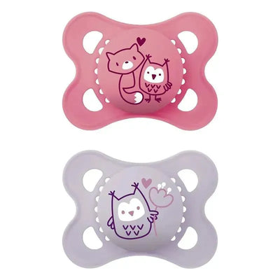 Two Mam Matte Deco Pacifiers for girls, one pink with a fox and owl design, and one lavender with an owl holding a heart.