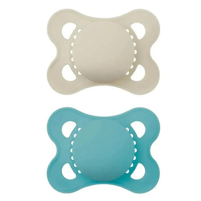 Two Mam Matte Deco pacifiers, one beige and one teal, designed for infants aged 6 to 16 months.