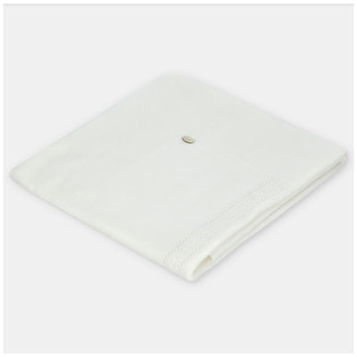 Knit white baby blanket by Martin Aranda, featuring a subtle texture and a small decorative detail.