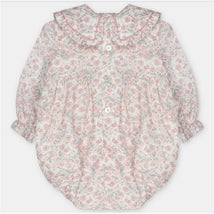 Baby girl short romper in woven fabric, featuring a floral pattern and ruffled collar, with button closure.