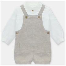 White long-sleeve shirt layered under a beige overall with two front pockets and button details.