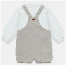 White long-sleeve shirt paired with beige overall shorts featuring two side pockets and adjustable straps.