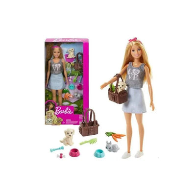 Blonde Barbie doll wearing a grey shirt and striped skirt, holding a pet carrier with a puppy, surrounded by pet accessories.