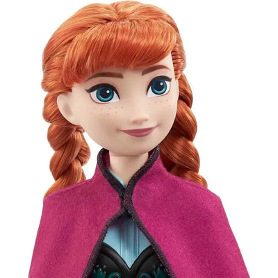 Disney Frozen Core Doll features Anna with braided red hair and a pink cape, showcasing her friendly expression and blue eyes.