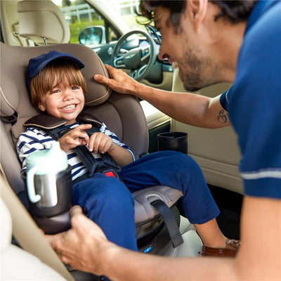 A smiling child in a striped shirt is safely buckled in a Maxi-Cosi Andi 360 car seat, while an adult adjusts the seat.