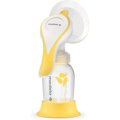 Manual breast pump with Flex Shields from Medela, featuring a white and yellow design, attached to a clear milk bottle.