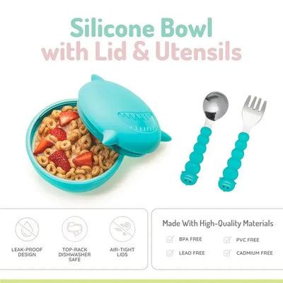 Silicone shark bowl with lid and utensils, featuring cereal and strawberries, in a vibrant teal color.