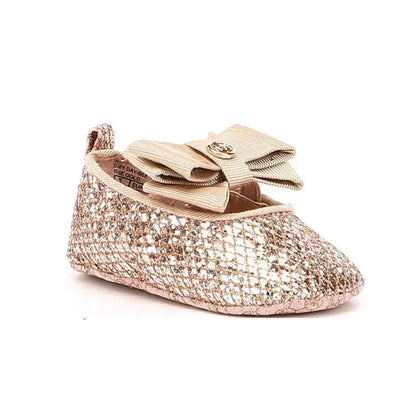 Rose gold ballet crib shoes by Michael Kors featuring a glittery exterior and a large ribbon bow on the top.