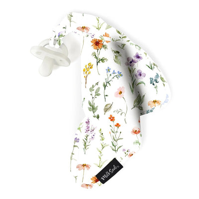 Soft white baby security blanket with colorful floral prints and an attached pacifier, branded Milk Snob.