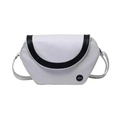Trendy Mima changing bag in snow white with a black curved flap and logo, designed for stylish baby care.