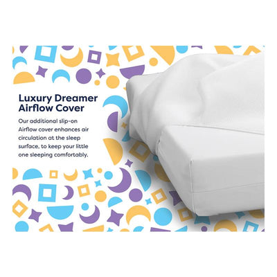 Luxury Dreamer Crib Mattress with an Airflow cover for enhanced air circulation, set against a colorful patterned background.