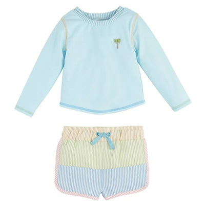 Baby boy seersucker rash guard in light blue with palm tree embroidery, paired with colorful striped swim trunks.