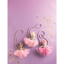 Three ballerina doll purses in pastel colors with tulle skirts, displayed on a purple background with confetti.