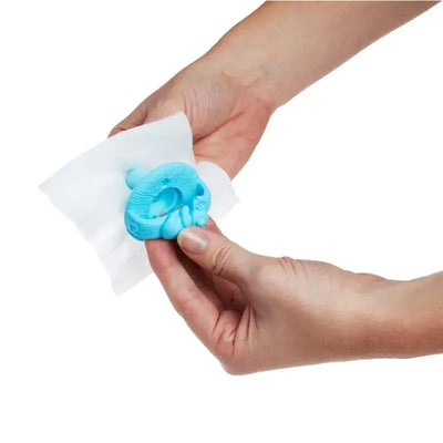 Munchkin Arm & Hammer Pacifier Wipes are being used to clean a blue pacifier held in a hand.